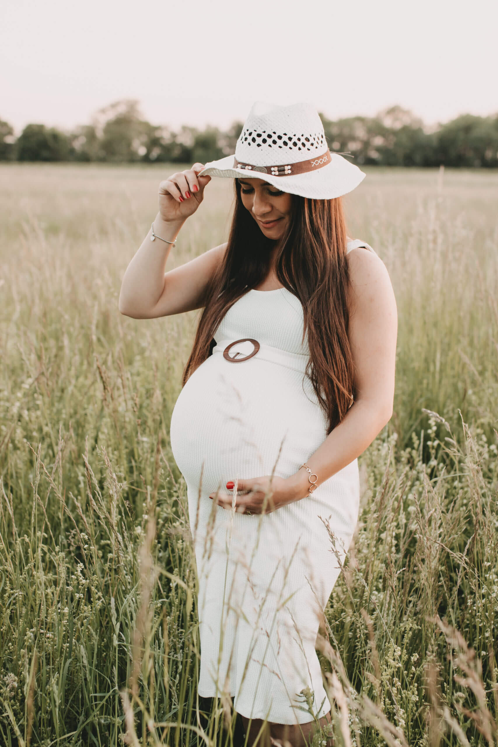 Babybauchshooting auf grüner Sommerwiese